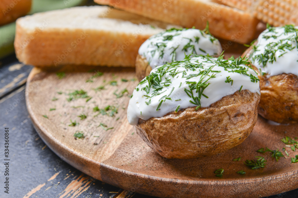 Tasty baked potato with sour cream on plate, closeup Tasty baked potato with sour cream on plate, closeup