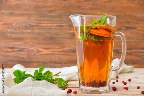 Jug of tasty cold tea on wooden table