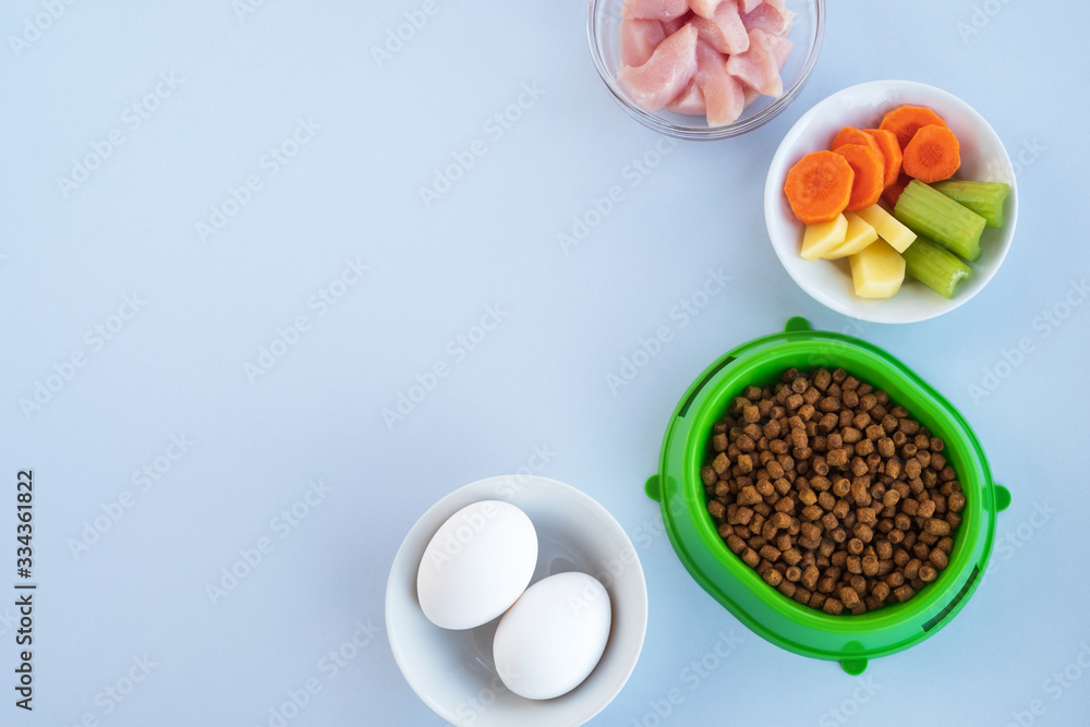 Pet food and ingredients of natural products on light background. Healthy diet for pets. Top view, flat lay, copy space Pet food and ingredients of natural products on light background. Healthy diet for pets. Top view, flat lay, copy space