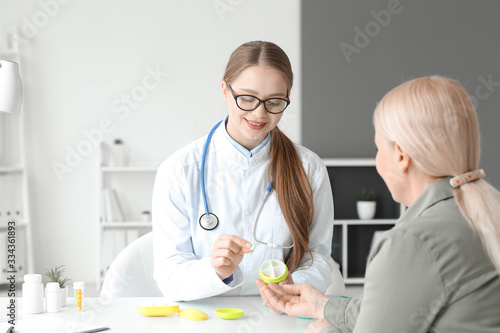 Doctor giving pills to pati...