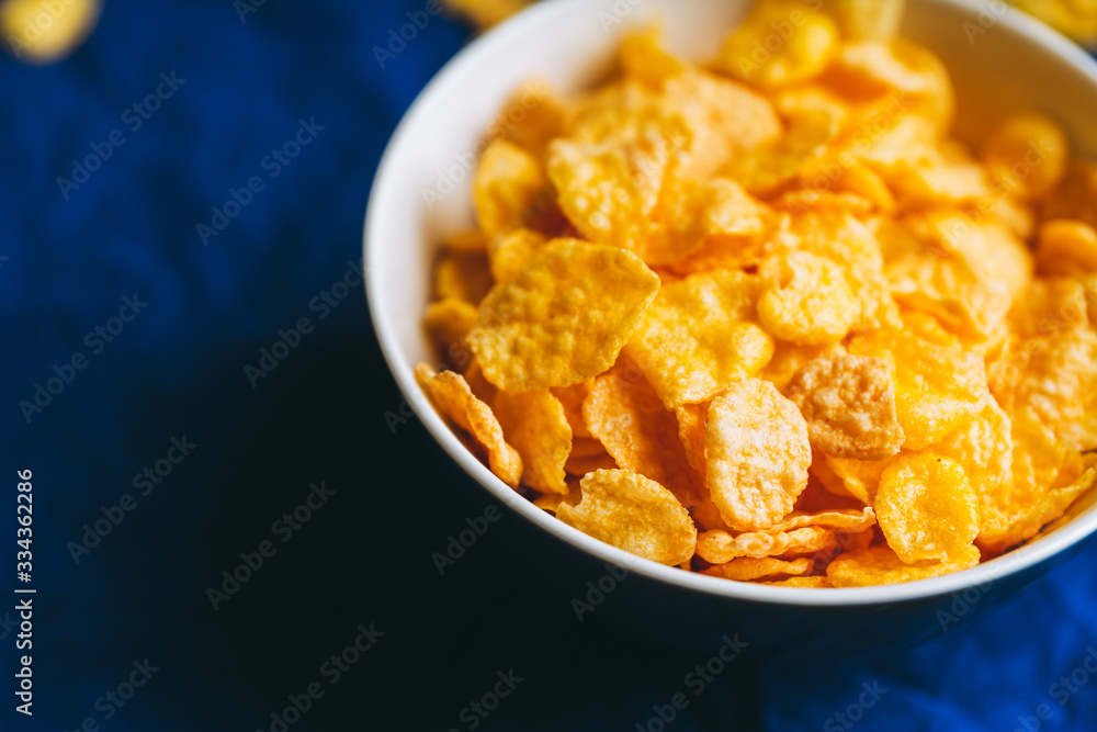 Tasty crispy corn flakes in bowl on the rustic background. Selective focus. Shallow depth of field. Tasty crispy corn flakes in bowl on the rustic background. Selective focus. Shallow depth of field.