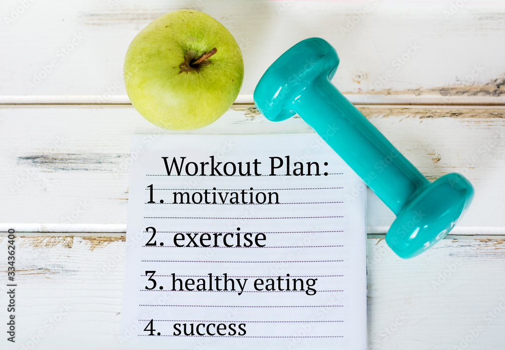 Workout Plan In Notebook .Fitness Plan Concept with Apple and Hand Weights Workout Plan In Notebook .Fitness Plan Concept with Apple and Hand Weights