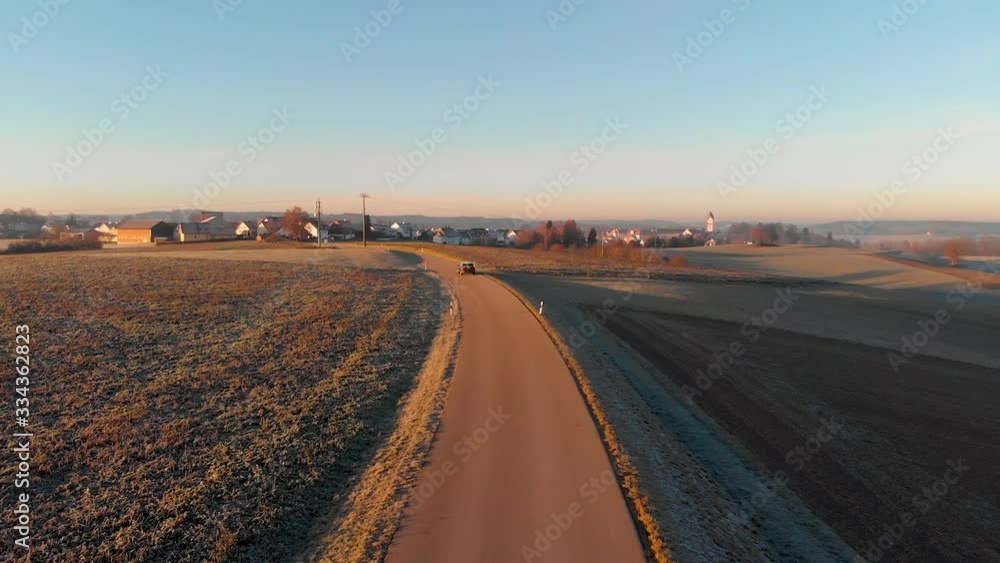 Low aerial drone following a car on country road with expansive views Low aerial drone following a car on country road with expansive views