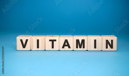 VITAMINS word cube on a blue background. Medical concept.