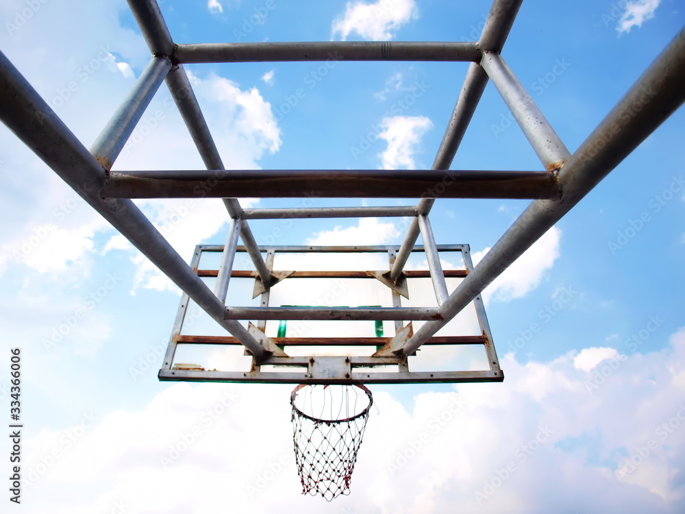 Close-up structure of outdoor basketball hoop On a background of colored sky and white sky clouds. Selective focus Close-up structure of outdoor basketball hoop On a background of colored sky and white sky clouds. Selective focus