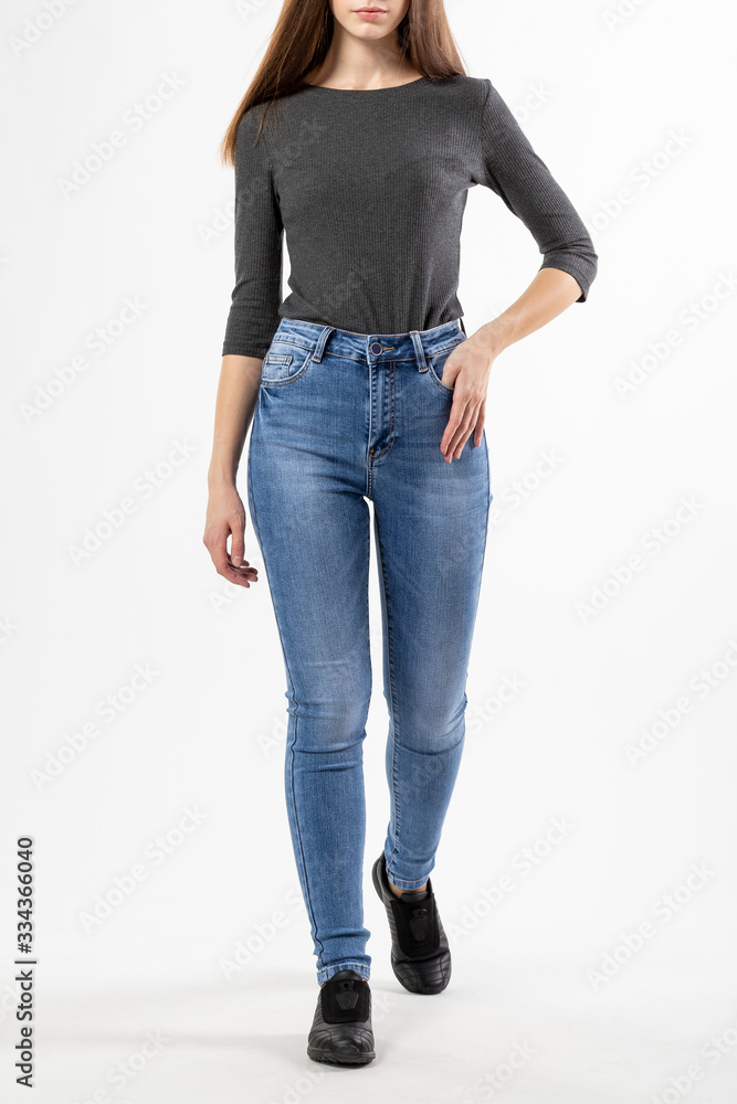 girl in jeans shows jeans on a white background close-up, blue jeans girl in jeans shows jeans on a white background close-up, blue jeans