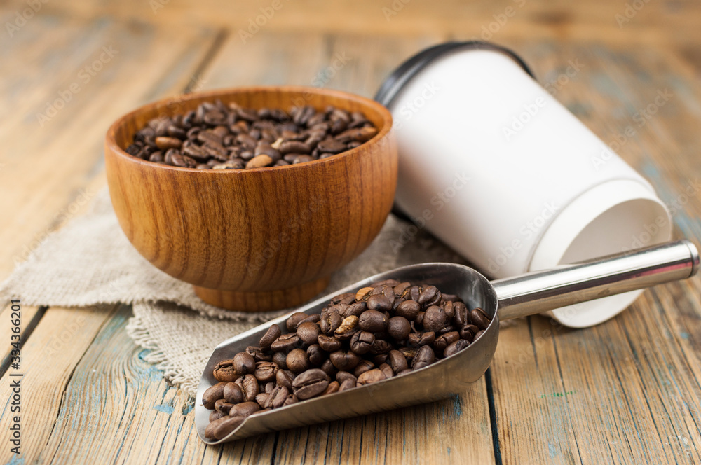 Disposable take-out mockup paper cups with coffee beans for morning espresso and brown bowl on wooden background Disposable take-out mockup paper cups with coffee beans for morning espresso and brown bowl on wooden background