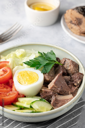 Salad with canned tuna, egg and vegetables - tomatoes, cucumber and lettuce.