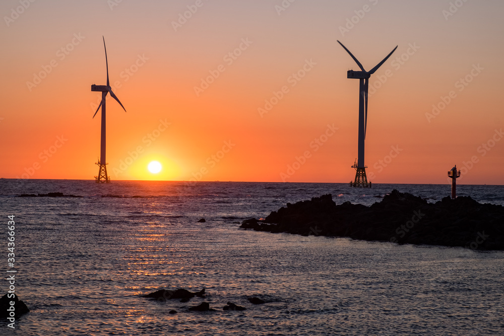 Beach sunset and wind power plant