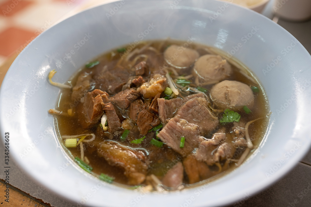 Braised beef soup And meatballs in a white bowl Closeup view from above Is a popular street food in Thailand. Braised beef soup And meatballs in a white bowl Closeup view from above Is a popular street food in Thailand.