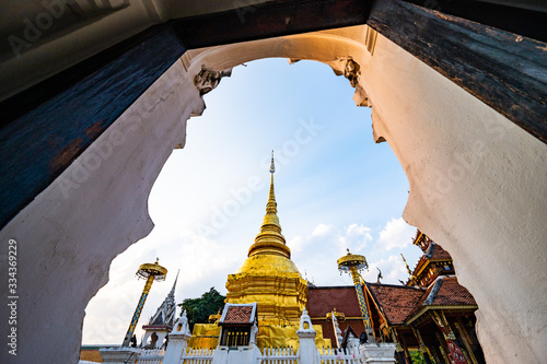 Thai style door frame with golden pagoda in Pong Sanuk temple photo