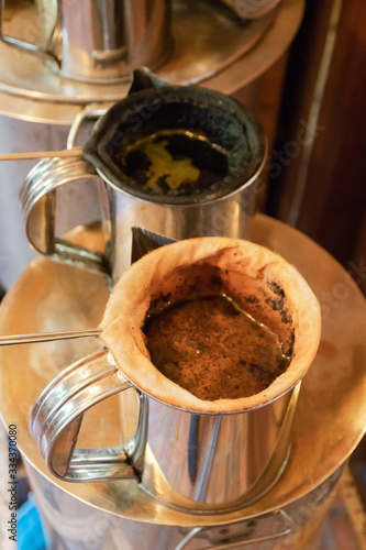 Making Thai coffee and tea using coffee bag in ancient stainless steel pot.