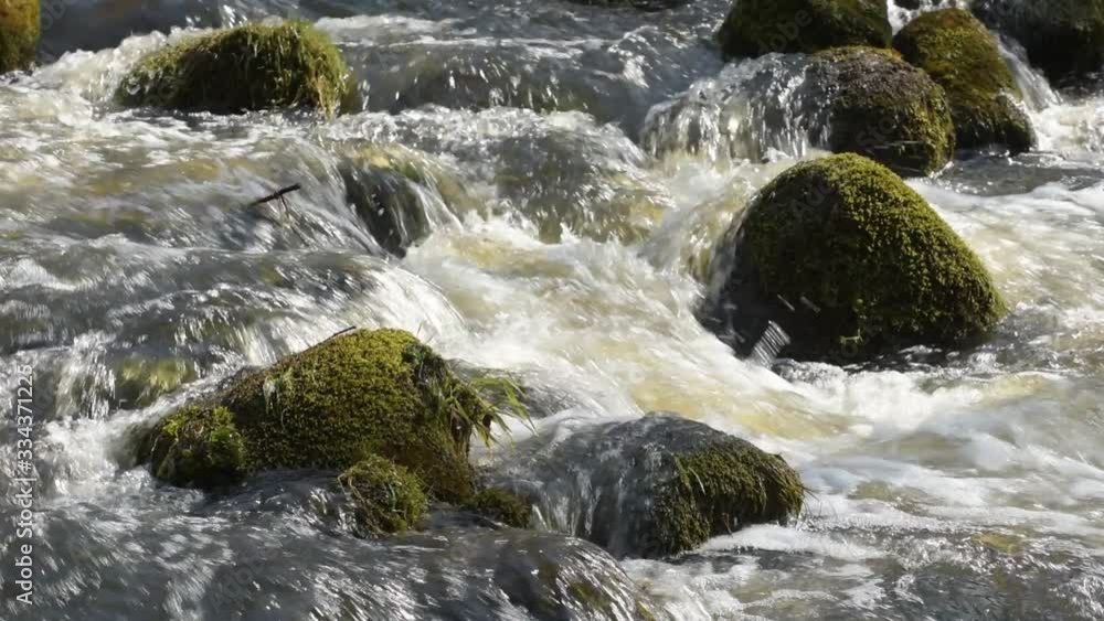 Close up of river stream flowing down over stones. Stock footage. Fast and cold brook with clear water flowing during spring time. Close up of river stream flowing down over stones. Stock footage. Fast and cold brook with clear water flowing during spring time.