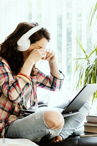 Tired Young Woman Working at Laptop at Her Home. Working From Home. Self Isolaton Quarantine photo