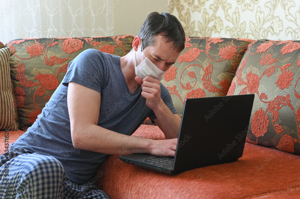 Sick man with laptop on sofa, close-up. Work from home during Coronavirus Covid-19. Quarantine and self isolation concept. Stay at home