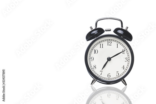 black alarm clock on white with reflection, space for text on the right