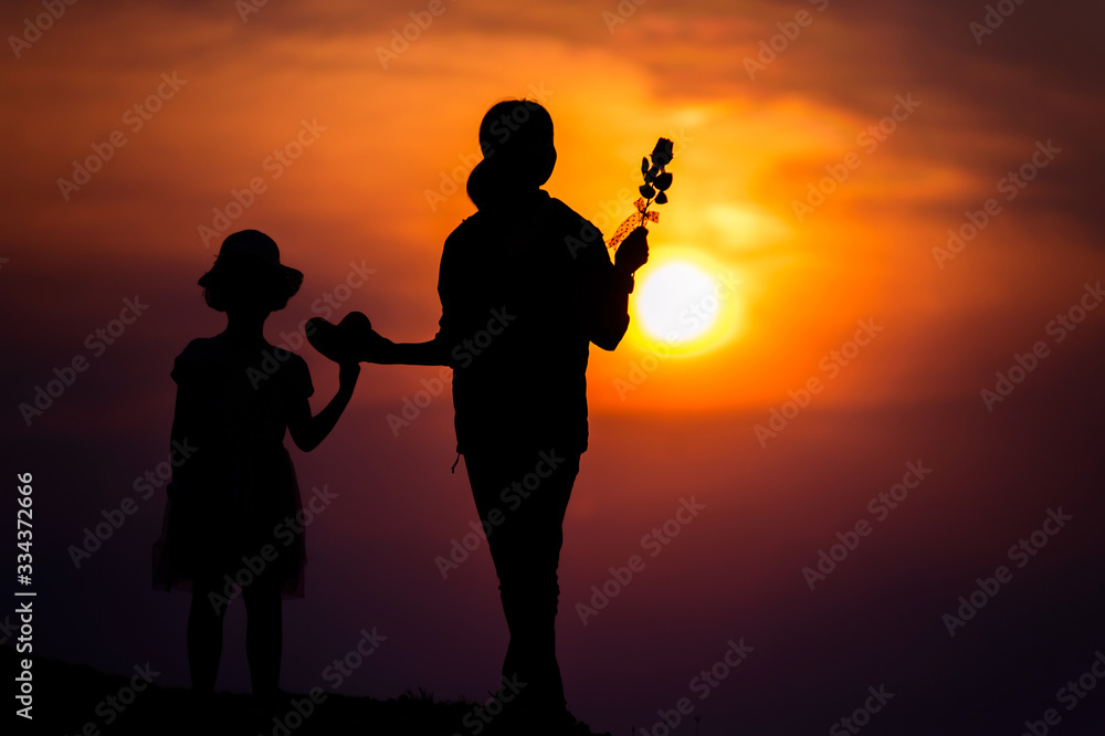 Naklejka premium silhouette of a family with a happy mother playing with a girl in the sunset sky