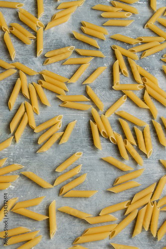 Food background - dry penne pasta, whole wheat uncooked ingredient