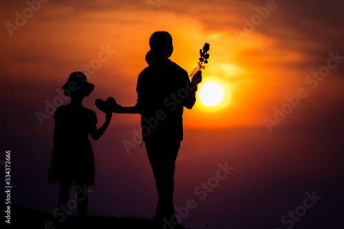 silhouette of a family with a happy mother playing with a girl in the sunset sky