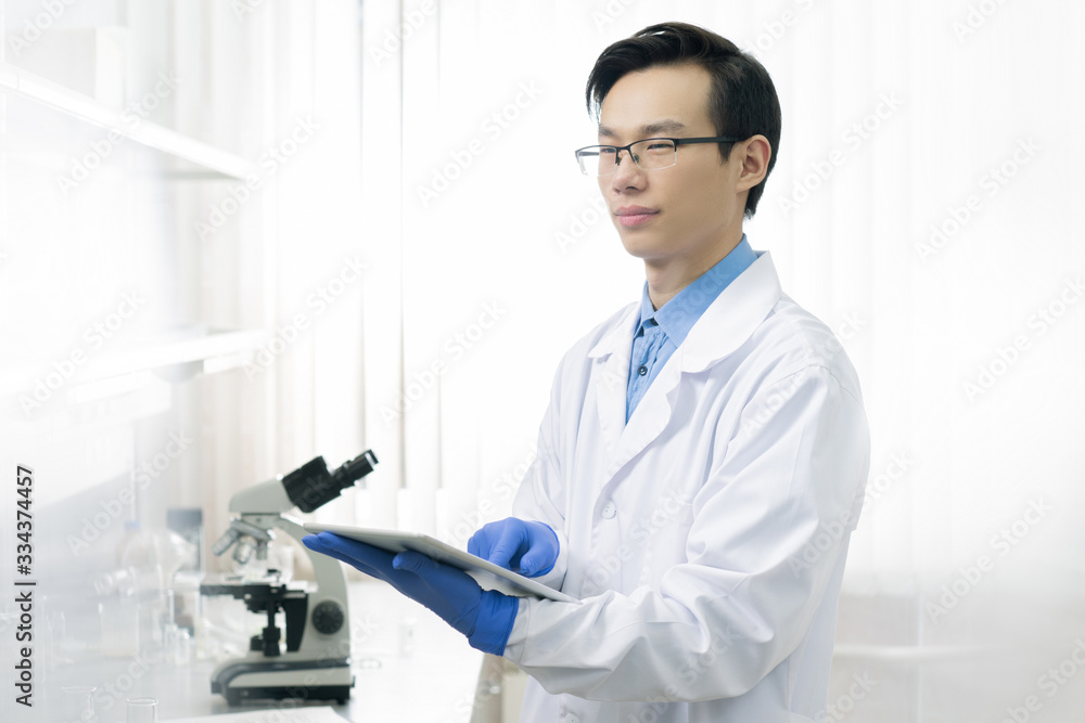 Young scientific researcher in workwear using touchpad to get online information Young scientific researcher in workwear using touchpad to get online information