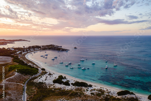 Aerial drone shot of a magical sunset over Rottnest Island, Perth, Western Australia. Geordie Bay below with luxury boats and yachts. 