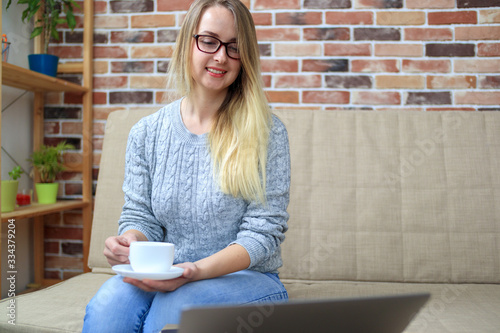Blonde woman make online shopping and drinking coffee photo