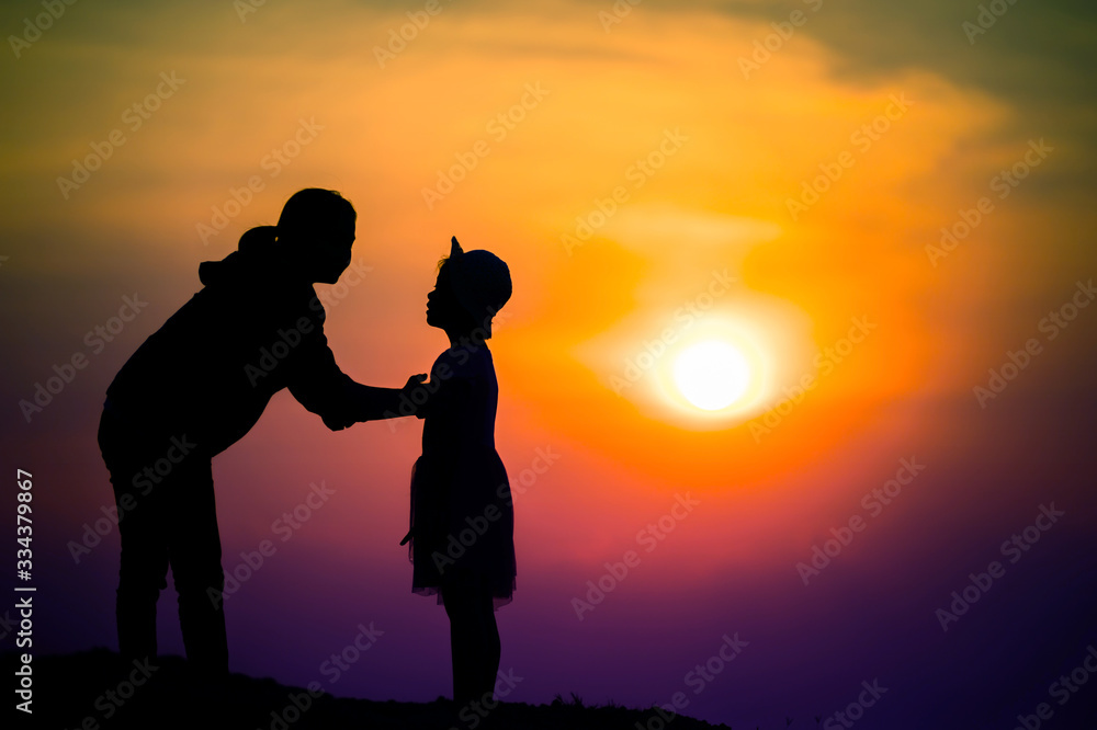 silhouette of a family with a happy mother playing with a girl in the sunset sky silhouette of a family with a happy mother playing with a girl in the sunset sky