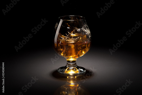 Ice cube fall and splash in beautiful glass goblet