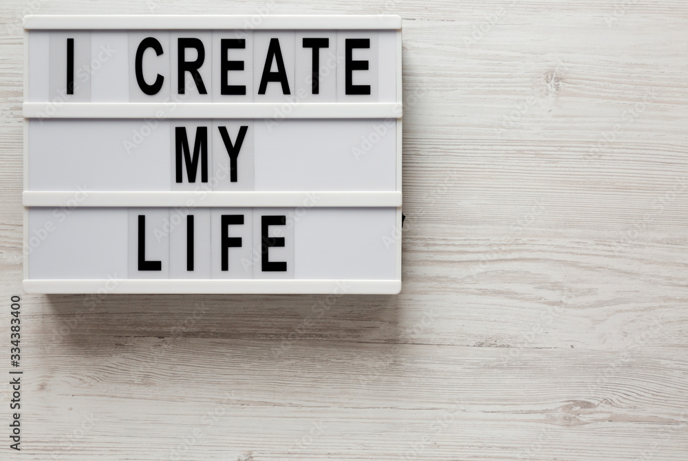 'I create my life' words on a modern board on a white wooden surface, top view. Overhead, from above, flat lay. Copy space. 'I create my life' words on a modern board on a white wooden surface, top view. Overhead, from above, flat lay. Copy space.