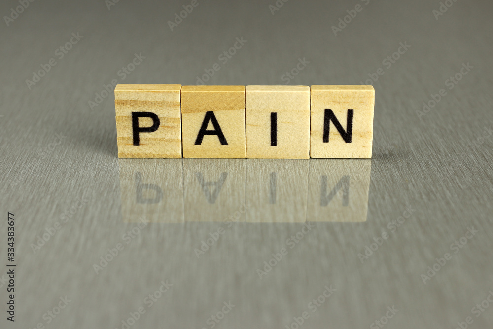 word pain is made of square wooden letters on a gray background word pain is made of square wooden letters on a gray background