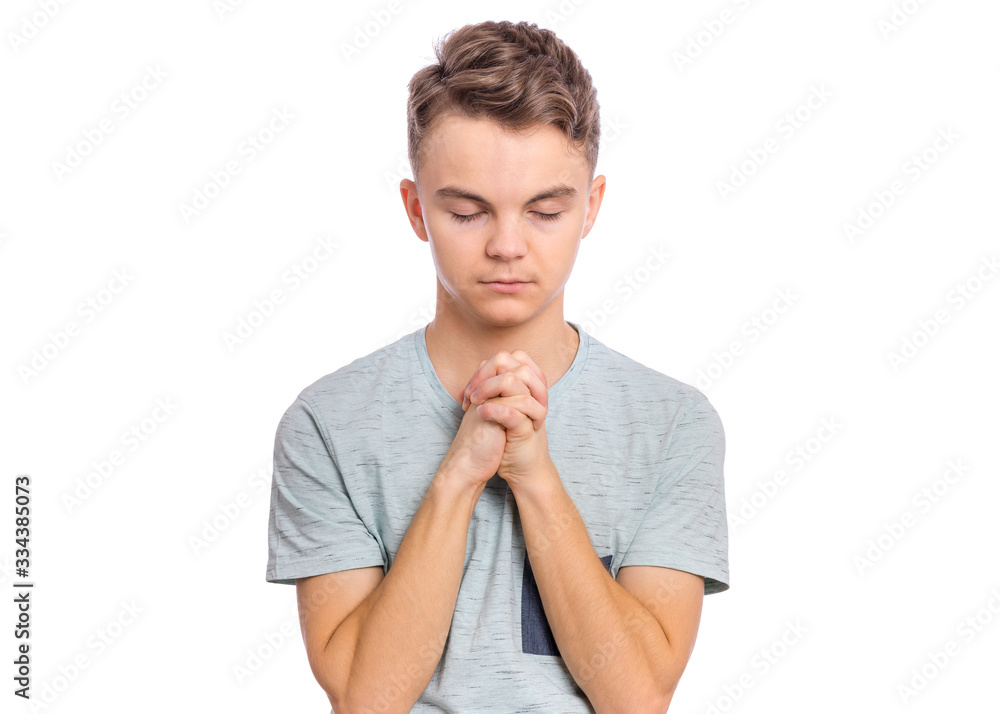 Portrait of teen boy praying, isolated on white background. Cute caucasian teenager with hands folded in prayer hoping for better. Child asking God for good luck, success or forgiveness. Portrait of teen boy praying, isolated on white background. Cute caucasian teenager with hands folded in prayer hoping for better. Child asking God for good luck, success or forgiveness.