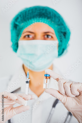 Vaccine bottle and syringe in a doctors hands close-up. COVID-19/ Coronavirus concept. 