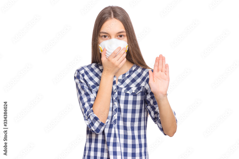 Concept of coronavirus quarantine. Child wearing medical protective face mask during flu virus, making stop gesture. COVID-19 - home self isolation. Teen Girl doing stop sign, isolated on white. Concept of coronavirus quarantine. Child wearing medical protective face mask during flu virus, making stop gesture. COVID-19 - home self isolation. Teen Girl doing stop sign, isolated on white.