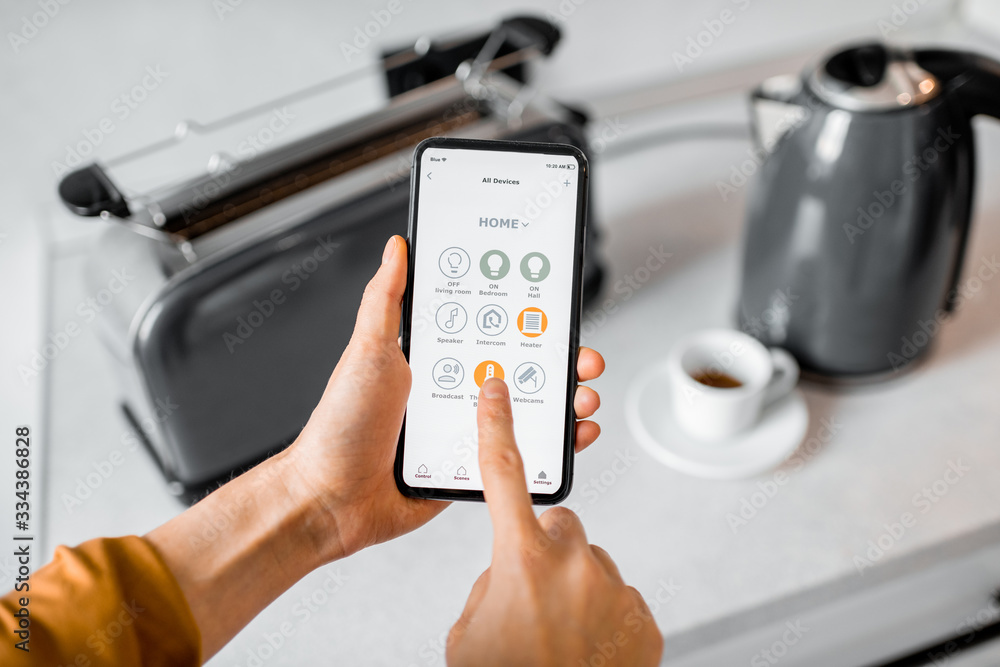Controlling smart kitchen appliance using mobile phone at home, close-up on mobile screen. Concept of a smart home devices
