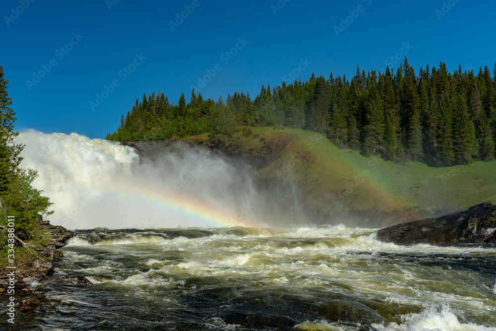 The waterfall Tannforsen in northern Sweden with a rainbow in the mist