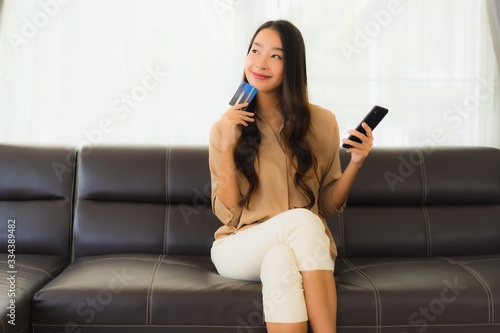 Portrait beautiful young asian woman using smartphone or cellphone with credit card