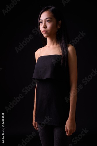 Portrait of young beautiful Asian woman looking away