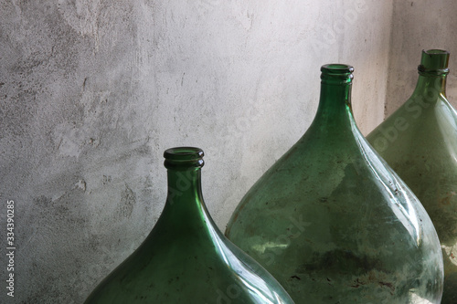 Primo piano di damigiane in vetro, contenitori per vino o aceto; oggetti vintage d’epoca photo