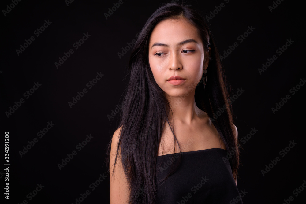 Face of young beautiful Asian woman thinking and looking down Face of young beautiful Asian woman thinking and looking down