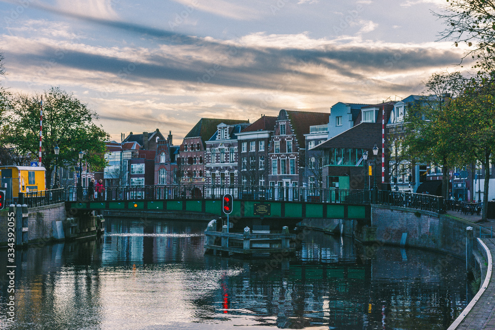 Obraz premium Cityscape of houses bordered by the Amsterdam canal, it is getting dark and the colors fade