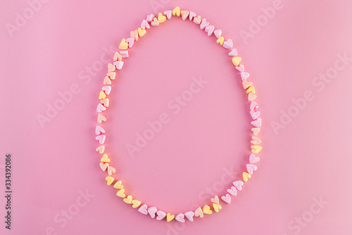 Multi-colored bright contour of an Easter egg from small cheerful hearts. Copy space. Concept