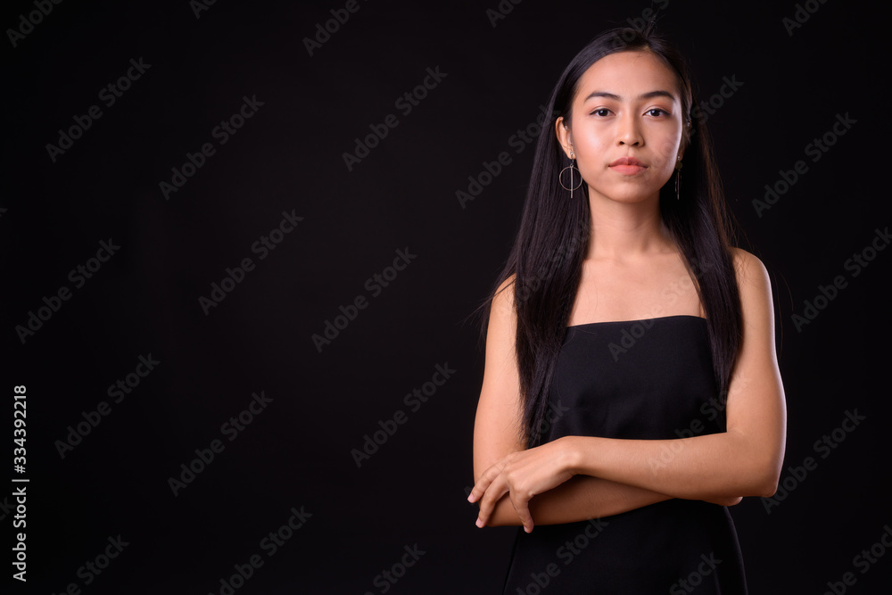 Portrait of young beautiful Asian woman with arms crossed