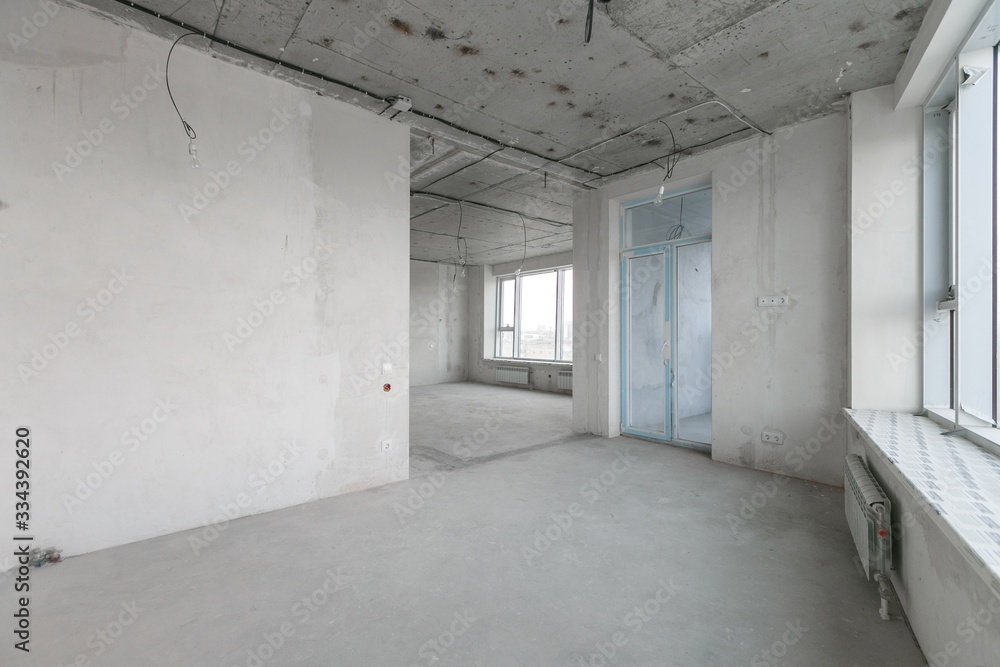interior of a new apartment without finishing in gray tones with electrical wiring interior of a new apartment without finishing in gray tones with electrical wiring