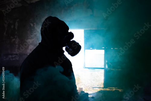 Dramatic portrait of a man wearing a gas mask in a ruined building. photo