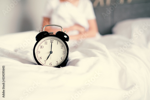 Woman sleep on the bed turns off the alarm clock wake up at the morning, Selective focus..
