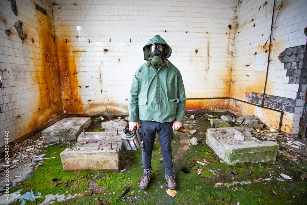 Dramatic portrait of a man wearing a gas mask in a ruined building. Dramatic portrait of a man wearing a gas mask in a ruined building.