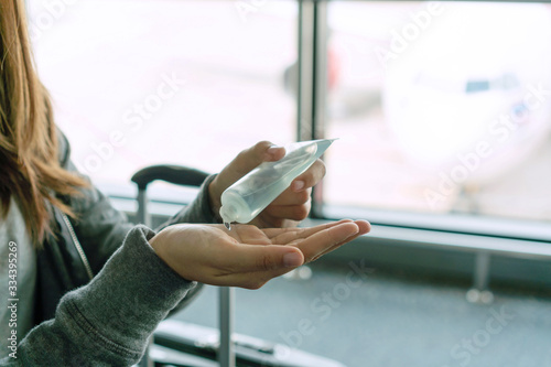 Woman applying sanitizer gel onto her hand for protection against infectious virus  bacteria and germs. Coronavirus  Covid-19  health care concept.