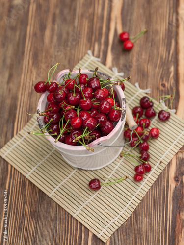 Fresh cherries in bowl on wooden table