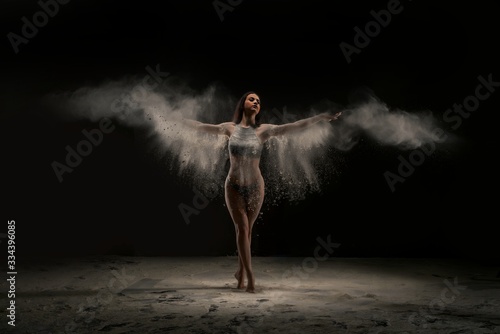 Slim woman in white dust cloud view