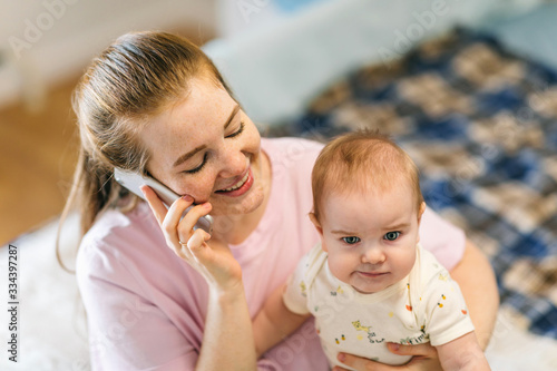 A young mother is talking on the phone in her arms with her baby. The child lacks attention. How to combine motherhood, self-development and personal affairs?